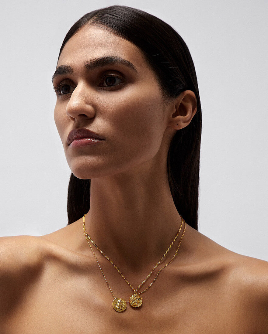 A stylish lady wearing a shimmering gold necklace, adding a touch of elegance and sophistication to her outfit.