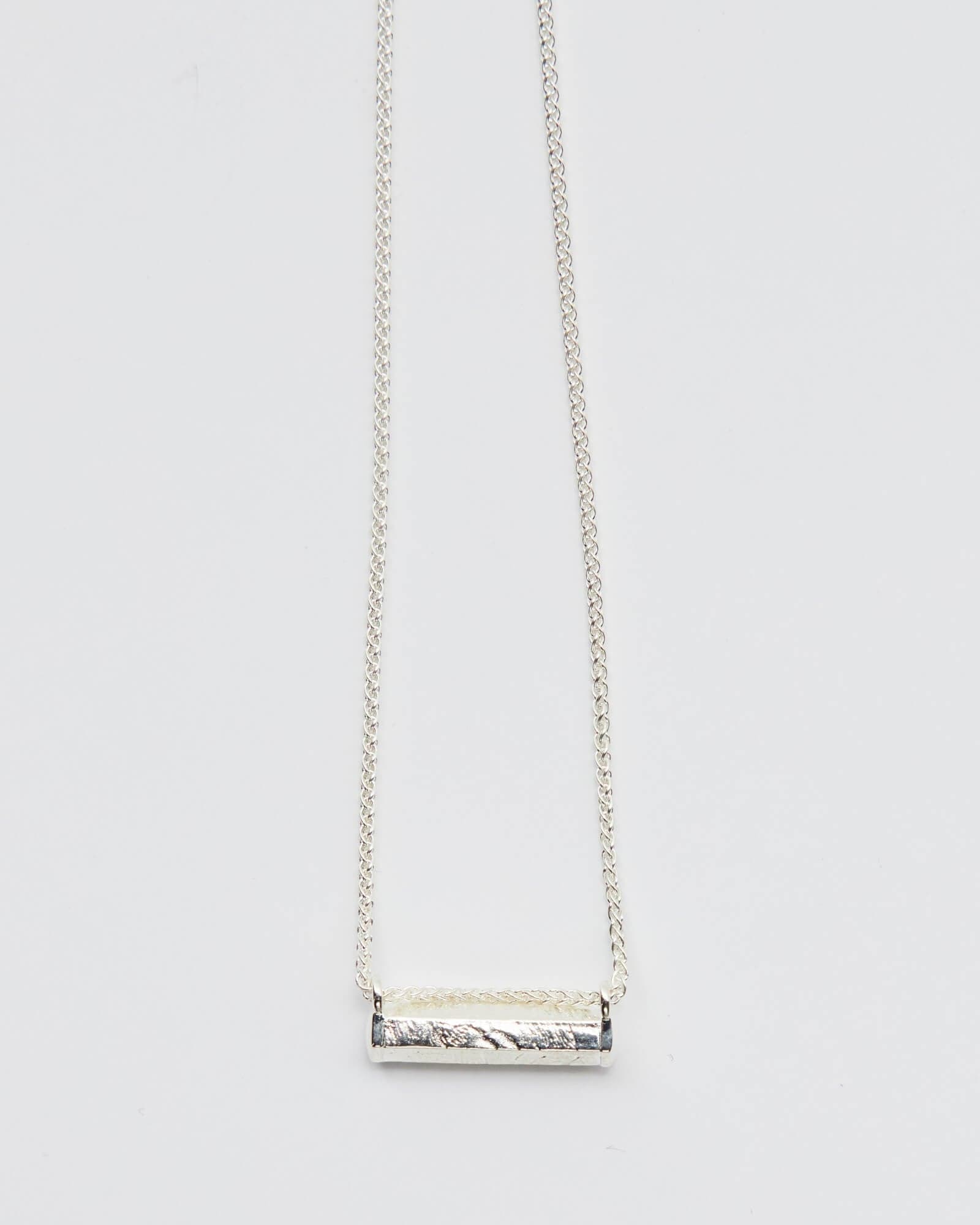 A stunning silver necklace on its own, featuring a delicate chain and a beautifully crafted pendant. The silver necklace adds a touch of elegance and sophistication to any outfit, making it the perfect accessory for any occasion