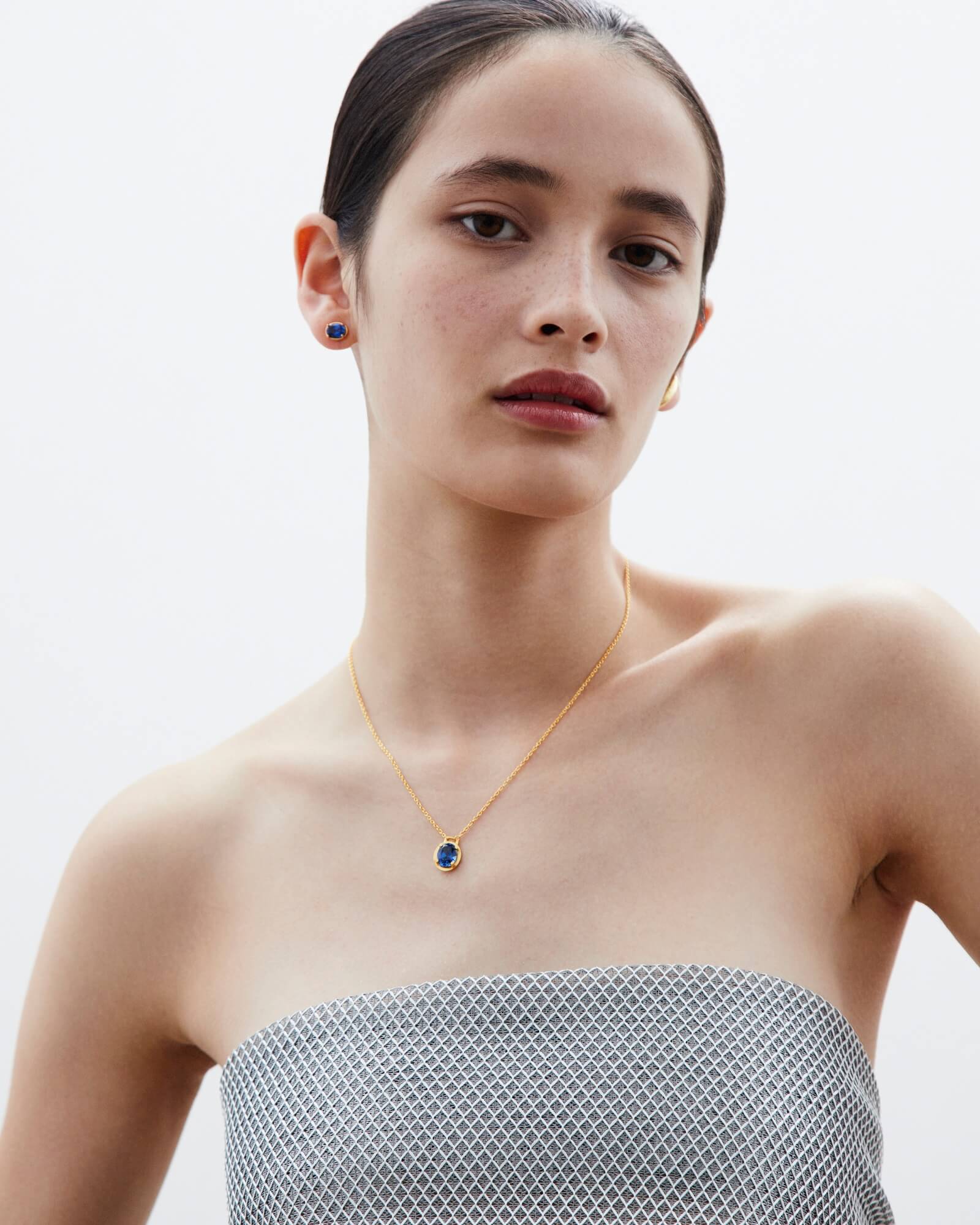 Image of a woman elegantly wearing Dear Letterman's gold gemstone jewellery, highlighting the intricate design and vibrant colours of the gemstone necklace.