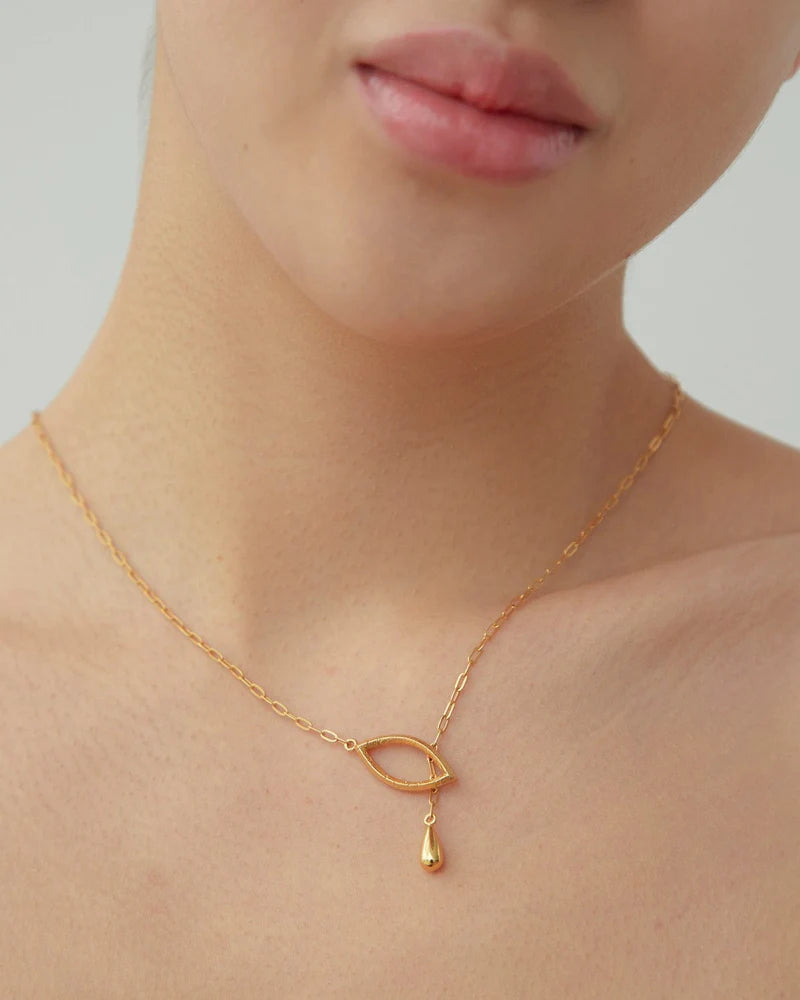 A confident and elegant woman showcasing the beauty of a gold necklace from Dear Letterman. 